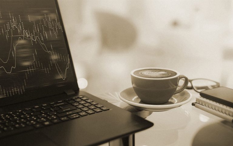 Laptop z wykresami danych i filiżanka kawy